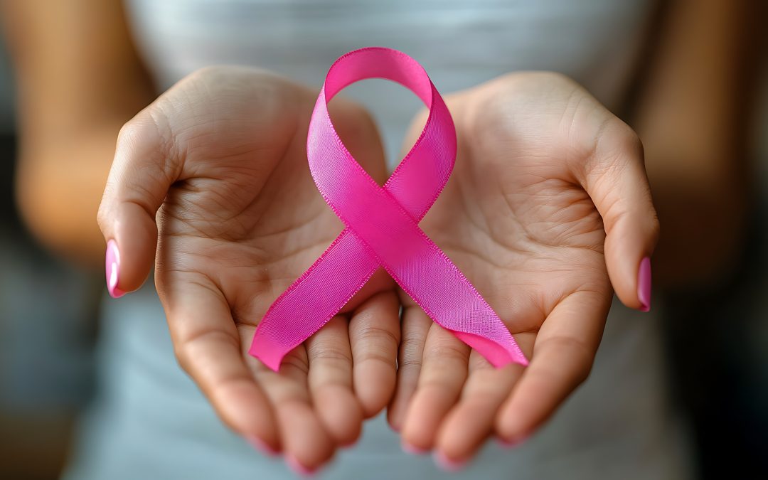 zwei Hände, welche eine rosa Schleife als Zeichen für die Brustkrebsprävention halten